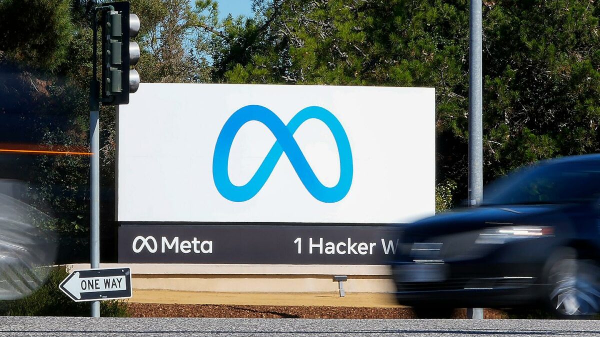 A car passes Facebook's new Meta logo on a sign at the company headquarters.