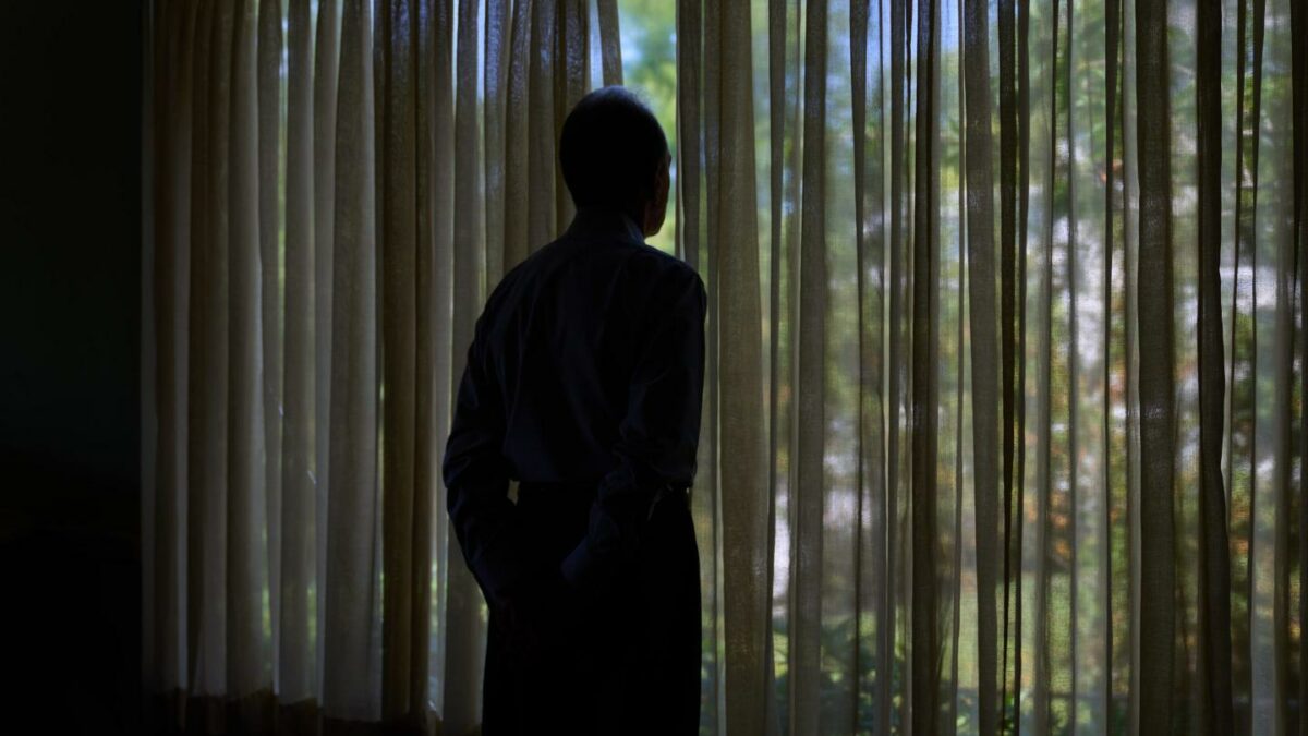 Simon, who was targeted by a scammer that stole $800,000 from his retirement savings and asked not to be identified by his full name because he's too ashamed to tell most of his family about the crime, looks out a window from his home.