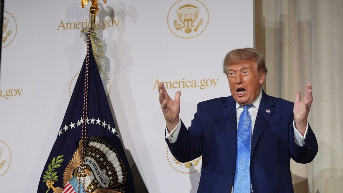 President Donald Trump gesturing as he speaks at the Andrew W. Mellon Auditorium.