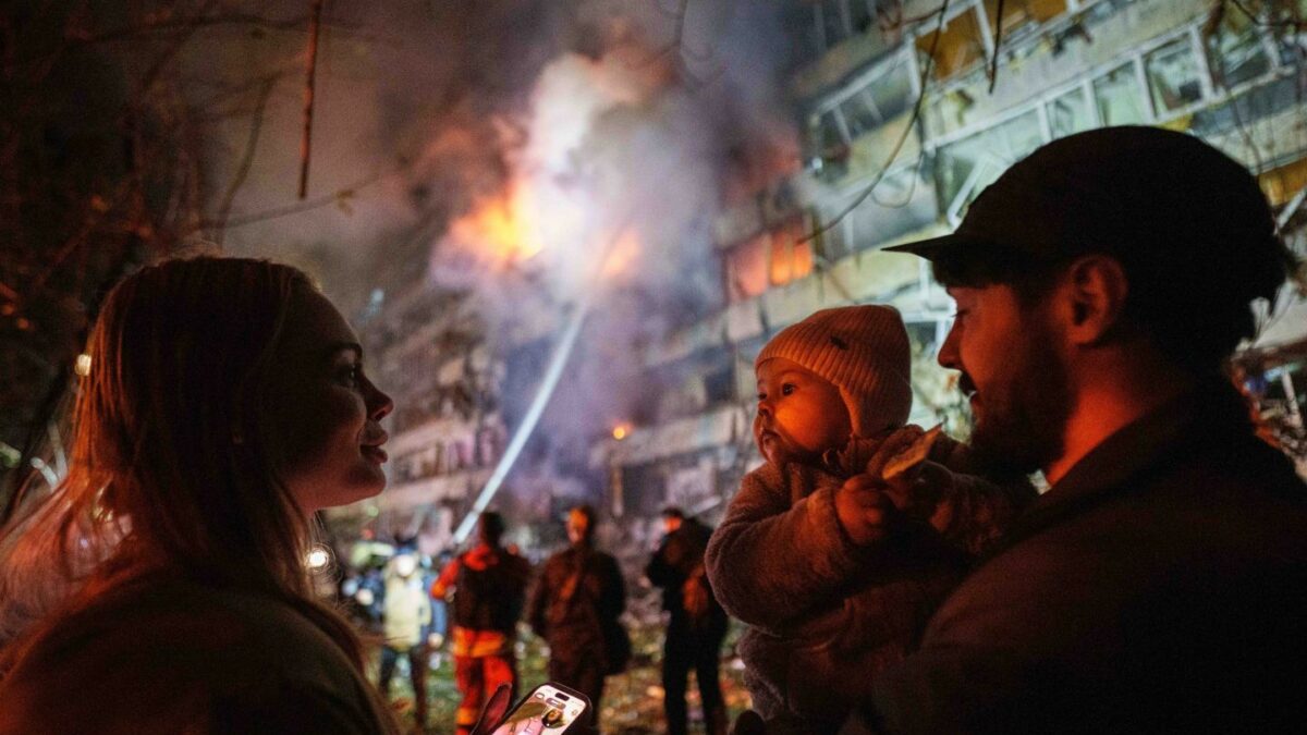 Victoria Deineko, her husband Ievhen Deineko and their daughter Mia look at a multi-story residential building damaged in a Russian missile strike in Kyiv, Ukraine.