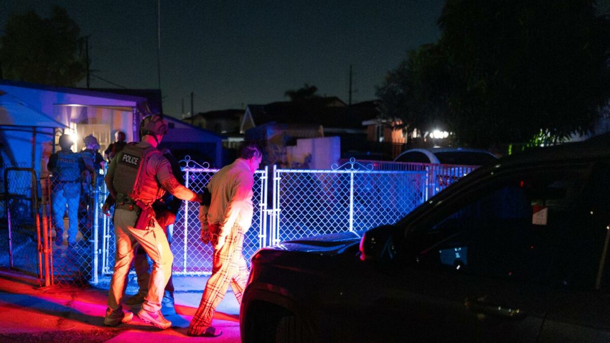 Homeland Security Investigations task force officers arrest a suspect accused of illegally registering to vote during a federal operation in Commerce.