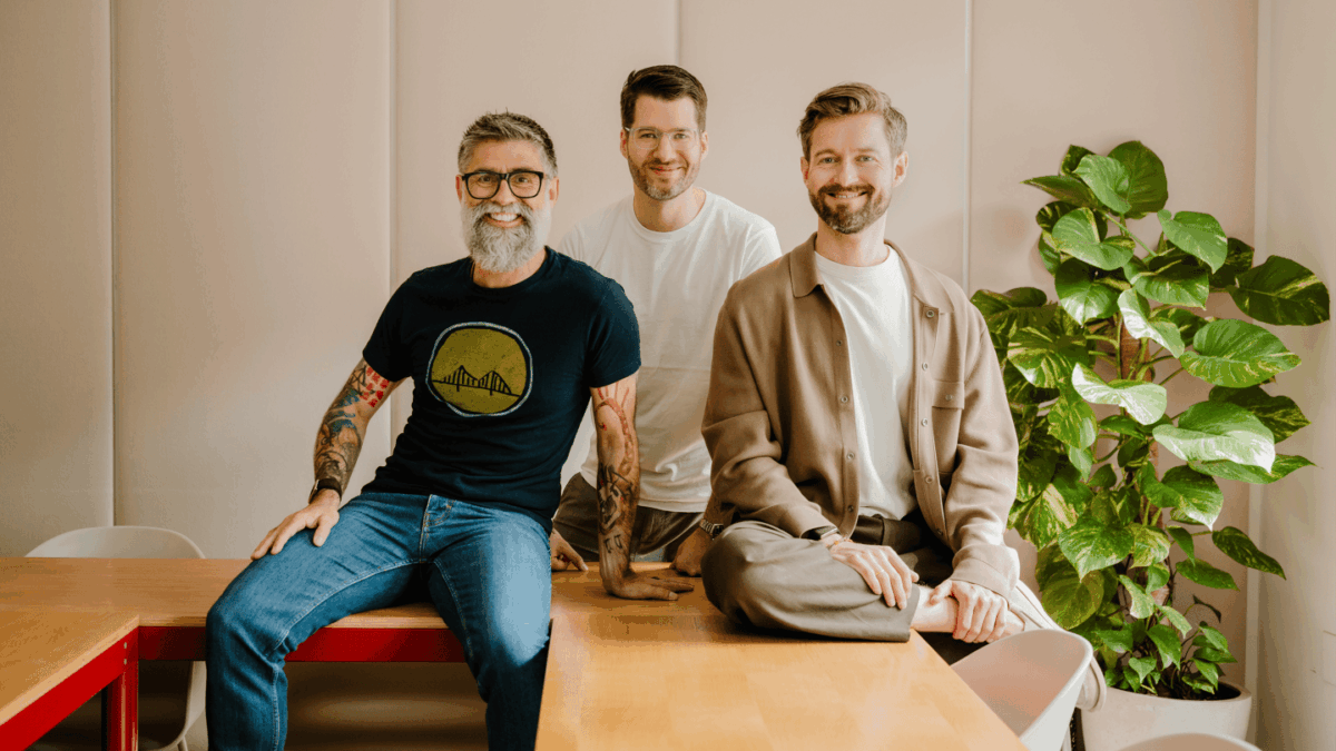Maex Ament (left), Philip Stanislaus (middle), and Henrik Gebbing) sit smiling at the camera.