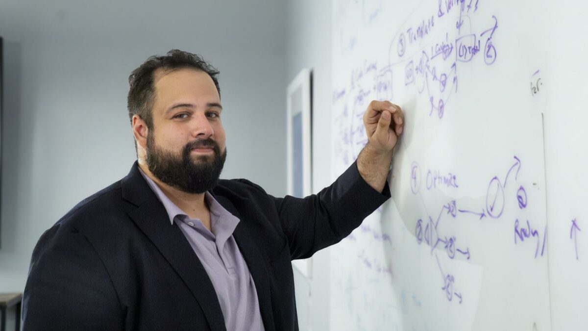 Peter Morales with his hand on a white board