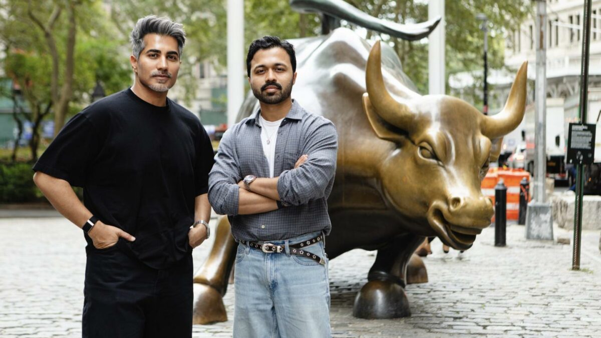 Mustafa Dar (left) and Nabeel Alamgir (right) stand in front of the Charing Bull, the bronze sculpture located in Wall Street.