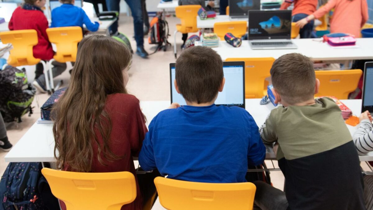 Pupils sit in front of a laptop during a press tour in a classroom of the Georgius Agricola Primary School.