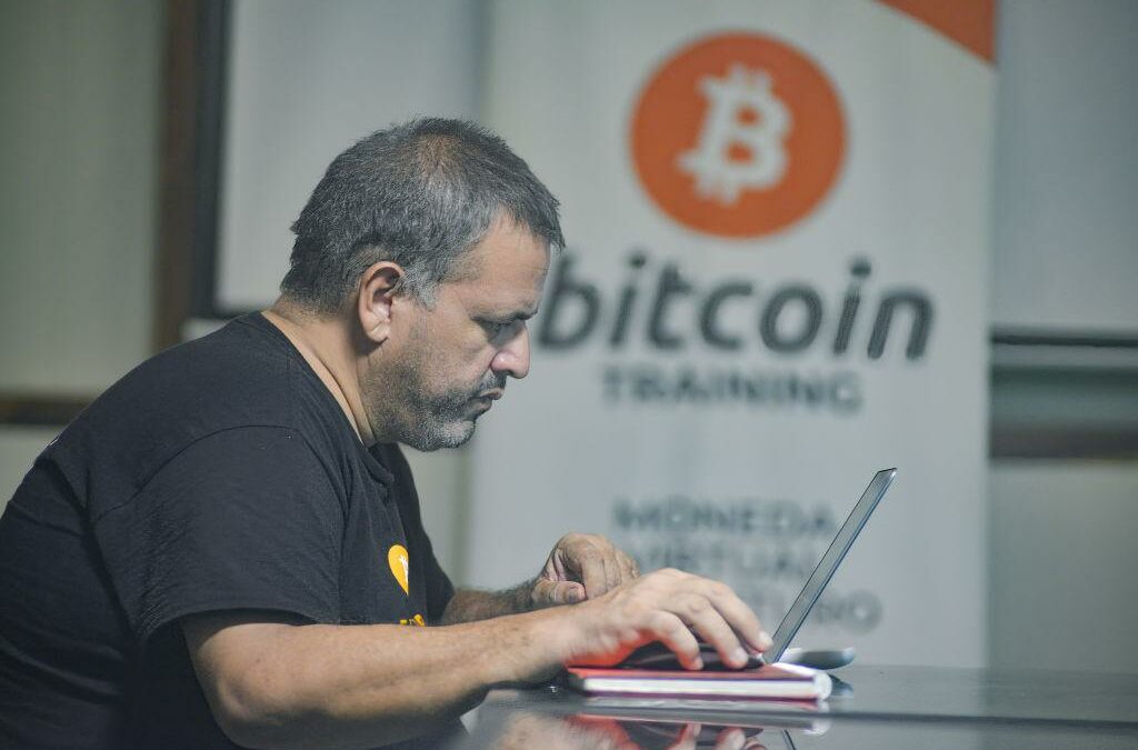 A man works on a laptop at a Bitcoin training facility.