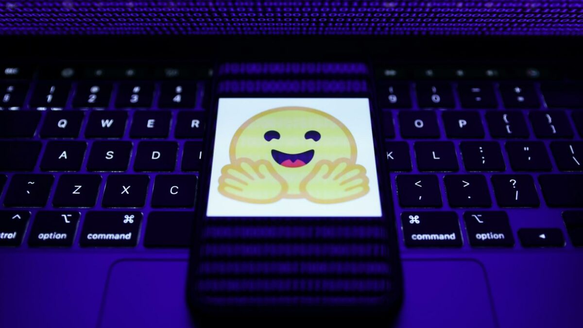 The Hugging Face logo on a smartphone resting on a laptop keyboard.
