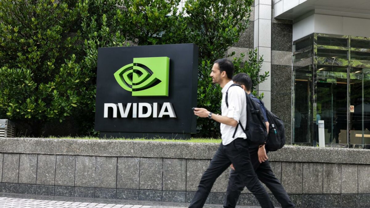 Nvidia employees walk past an Nvidia sign outside its offices
