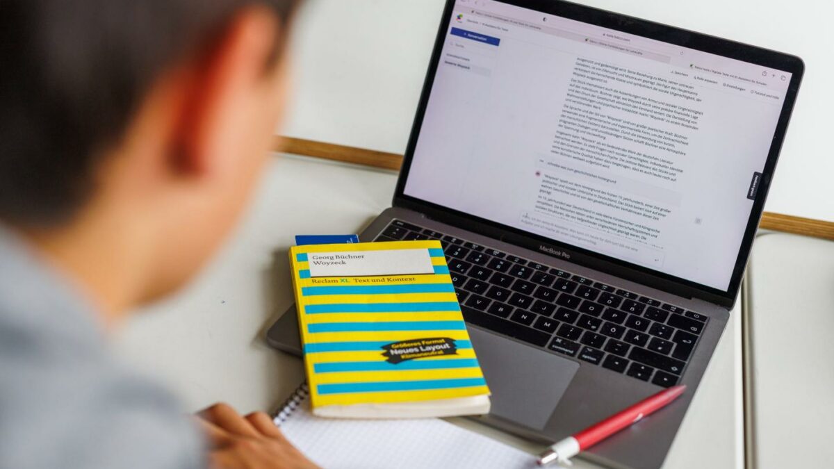 A student at a high school sits in front of a laptop and uses an AI tool.