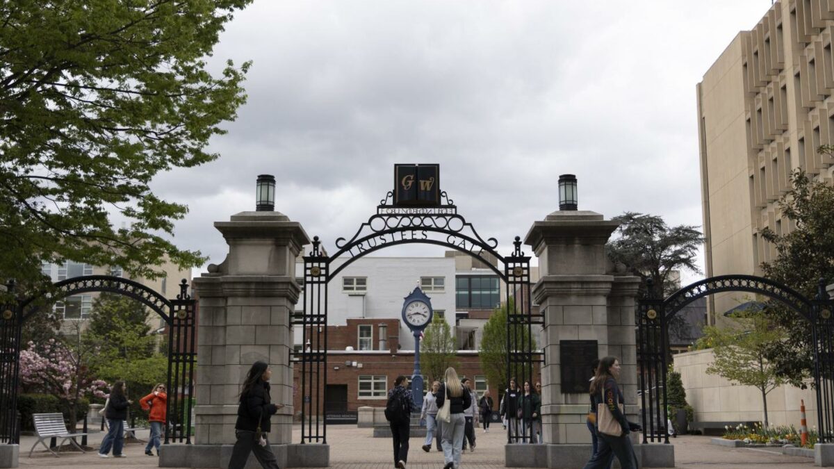 Students walk past the Trustee's Gate on George Washington University's campus.