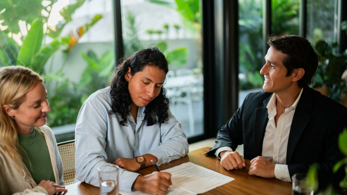 Two men and a women review a resume