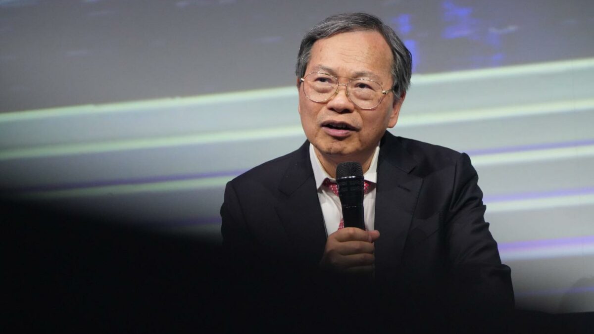 seated man speaks into microphone
