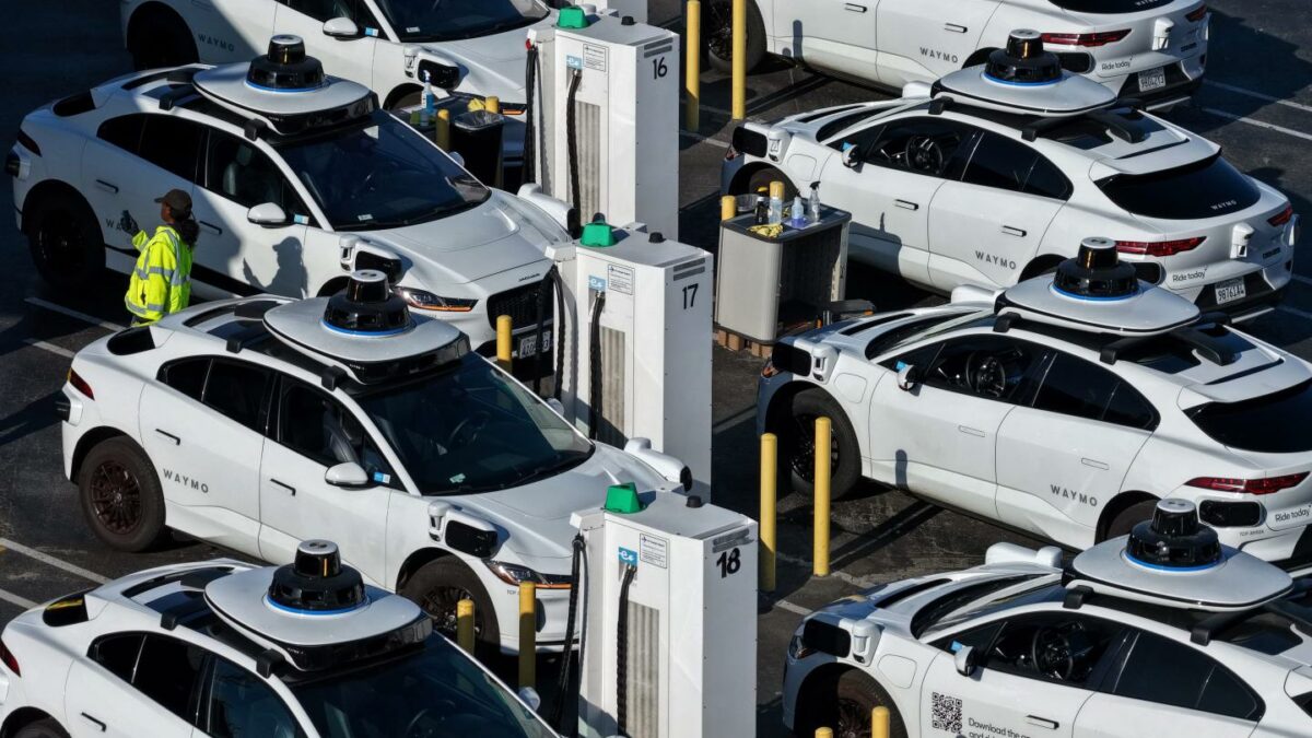 In an aerial view, Waymo robotaxis sit parked at a Waymo facility.