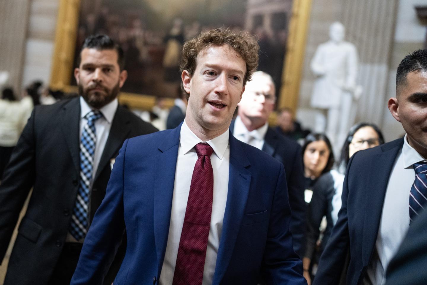 gettyimages-2267943807-e1786995029177-1 Mark Zuckerberg wears a blue suit, white shirt, and red tie