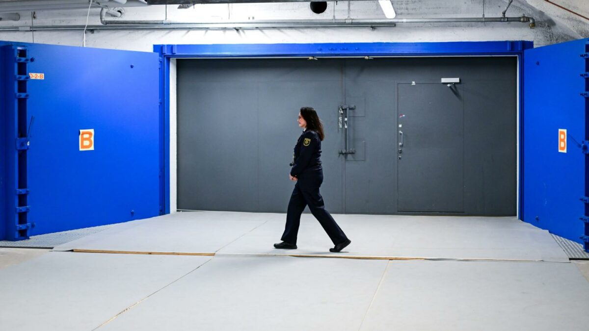 A woman from the City of Helsinki's Emergency Services and Fire Department walks past a bunker door during a visit by the foreign minister to the Merihaka civil defense facility.
