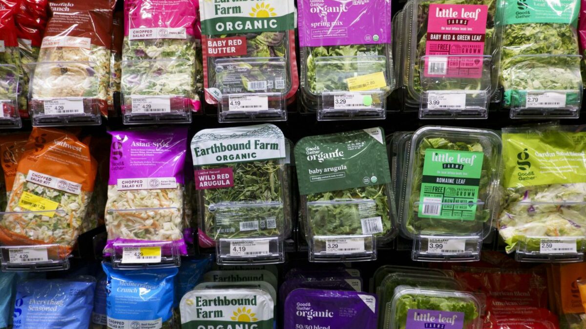 Packaged salad mixes are displayed in the refrigerated produce section of a Target store.