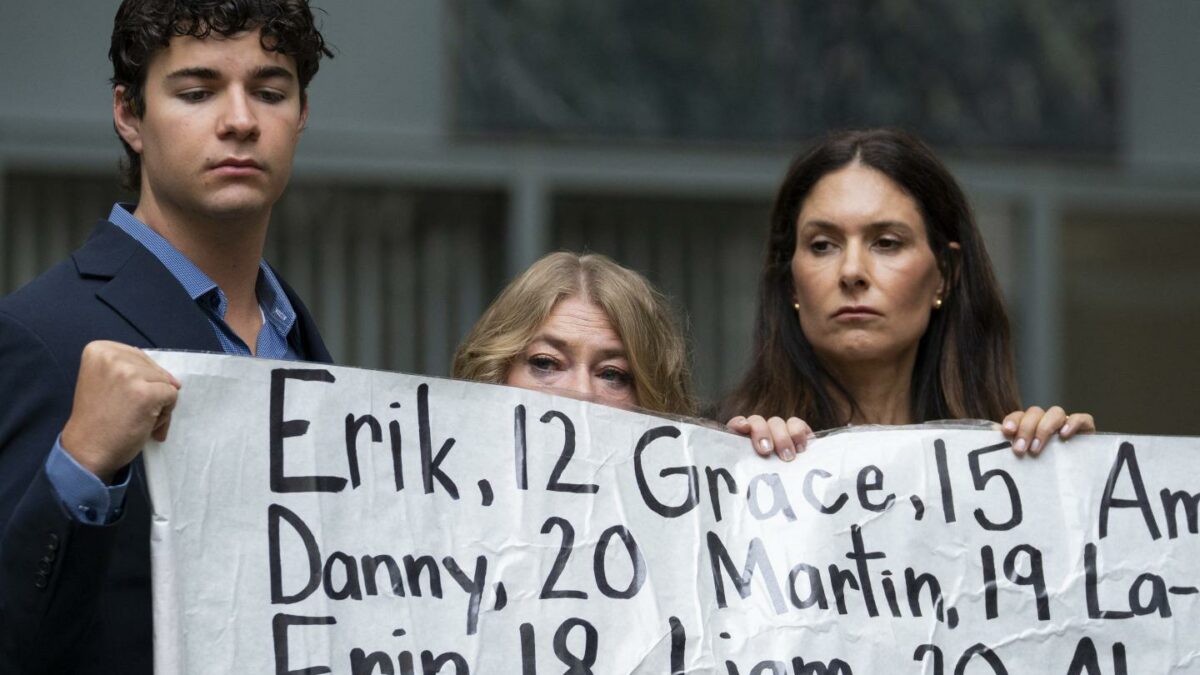 Dawson Kelly, Victoria Hinks and Lisa Pearson hold a banner naming nearly 400 young people whose deaths they say were linked to social media outside the federal courthouse in Oakland, Calif., as Meta’s child-safety trial begins.