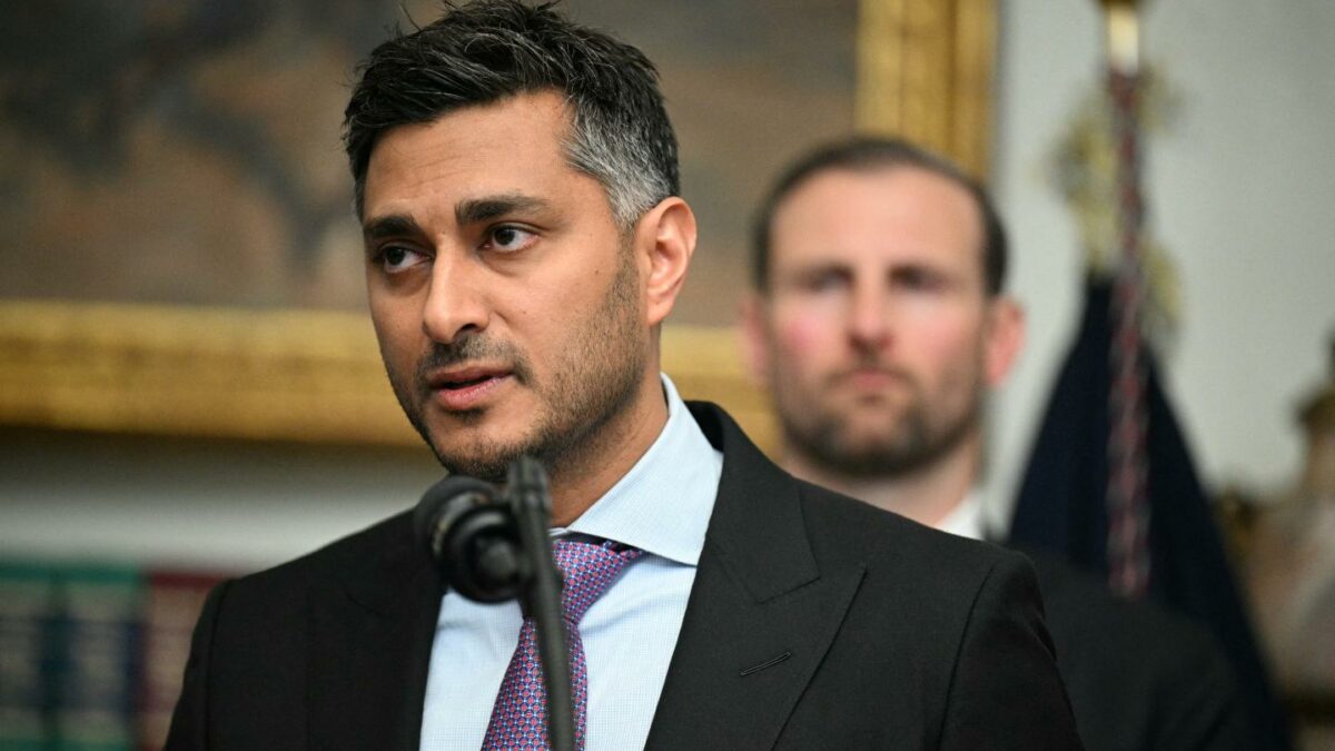 Payward Co-CEO Arjun Sethi wears a suit as he speaks through a microphone