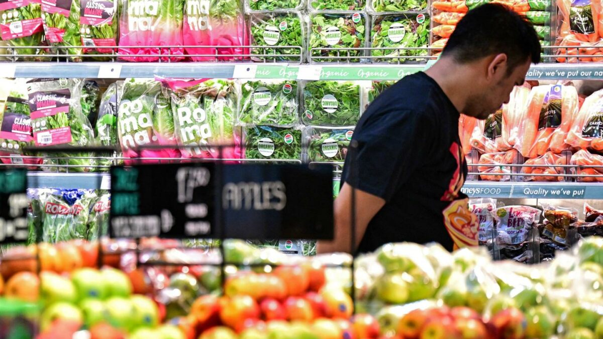 A man shops for produce in a supermarket.