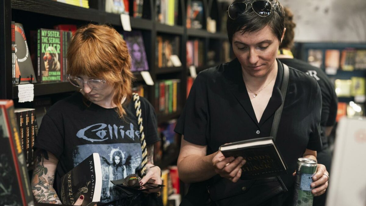 Two people browse books in a bookstore.