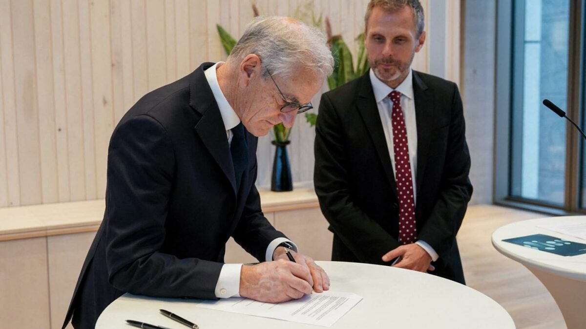 Norway's Prime Minister Jonas Gahr Støre (L) and Norway's Minister of Digitalisation and Public Administration Torgeir Micaelsen sign a letter of intent on the responsible introduction and use of artificial intelligence in the workplace, in Oslo, Norway.