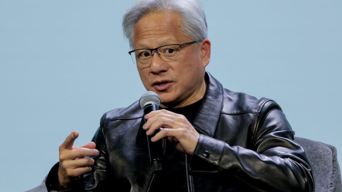 Jensen Huang speaks, holding a microphone
