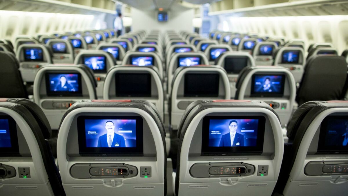 Screens are illuminated in the economy-class cabin on board an American Airlines Group Inc. Boeing Co. 777-300ER aircraft at Hong Kong International Airport in Hong Kong, China, on Friday, June 13, 2014.