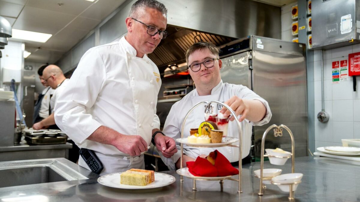 A chef at one of Hilton's hotels works with a junior member of staff